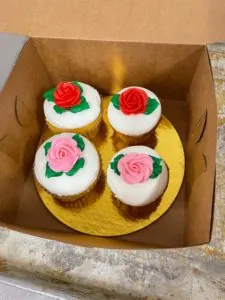 Box of four mini cupcakes decorated with red and pink frosting roses