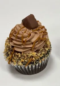 Chocolate frosted cupcake with caramel drizzle and candy bar topping