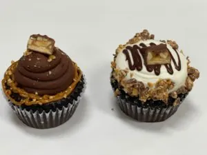 Two candy bar cupcakes with chocolate and caramel frosting