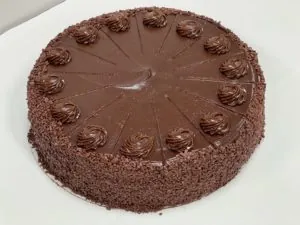 Whole chocolate cake with chocolate rosettes and chocolate shavings
