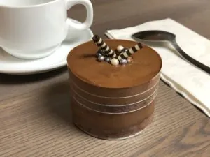 Individual chocolate mousse cake with chocolate curls, served with coffee