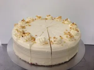 Sliced vanilla cream cake with whipped cream rosettes