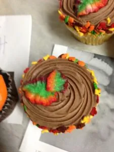 Fall cupcakes with chocolate frosting and leaf decorations