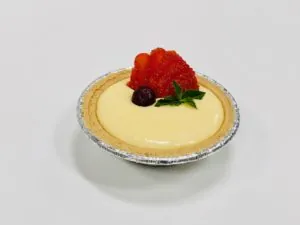 Mini cheesecake tart topped with fresh strawberries and mint